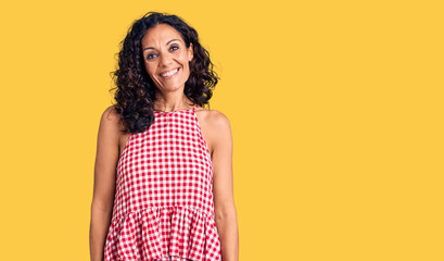 Obraz premium Middle age beautiful woman wearing casual sleeveless t shirt looking positive and happy standing and smiling with a confident smile showing teeth