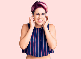 Fototapeta premium Young beautiful woman with pink hair wearing casual clothes covering ears with fingers with annoyed expression for the noise of loud music. deaf concept.