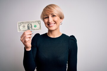 Young blonde woman with short hair holding one dollar banknote over isolated background with a happy face standing and smiling with a confident smile showing teeth