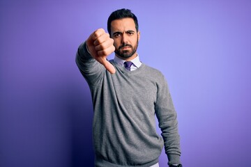 Obraz premium Handsome businessman with beard wearing casual tie standing over purple background looking unhappy and angry showing rejection and negative with thumbs down gesture. Bad expression.