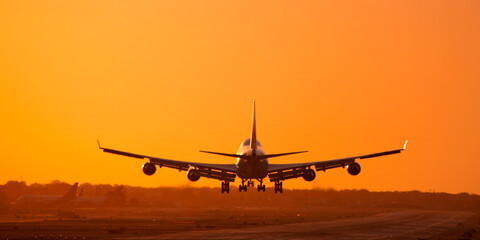 Naklejka na ściany i meble 747 Jumbo Jet landing at sunset