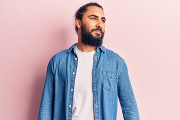 Fototapeta premium Young arab man wearing casual clothes looking to side, relax profile pose with natural face and confident smile.