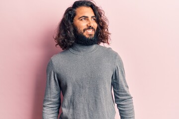 Young arab man wearing casual clothes looking to side, relax profile pose with natural face and confident smile.