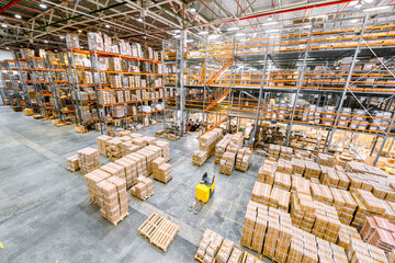 Large industrial warehouse. Many cardboard boxes stand on a loading dock