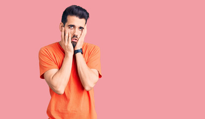 Young handsome man with beard wearing casual t-shirt tired hands covering face, depression and sadness, upset and irritated for problem