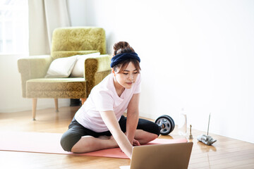 トレーニングの方法をPCで調べる女性