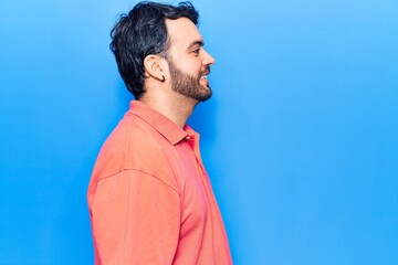 Young hispanic man wearing casual clothes looking to side, relax profile pose with natural face with confident smile.