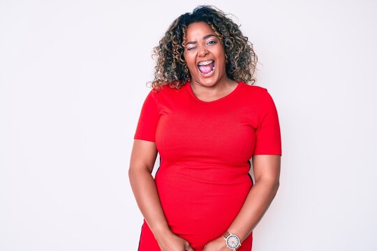 Young african american plus size woman wearing casual clothes winking looking at the camera with sexy expression, cheerful and happy face.