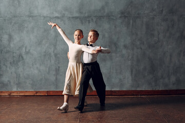 Young couple boy and girl dancing in ballroom dance Viennese Waltz.
