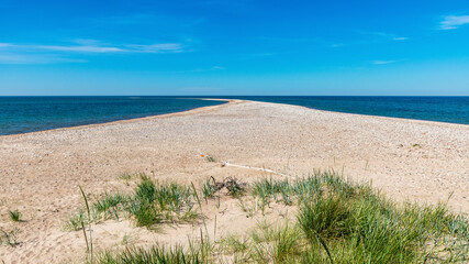Fototapeta na wymiar traditional summer landscape with sandy and pebbly promontory, blue sea and sky, Harilaid Nature Reserve, Estonia, Baltic Sea