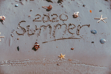 summer 2020 text on sand beach shells and starfish around