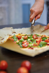 woman hand slicing pizza for pieces