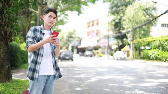 Asian man waiting for Uber taxi