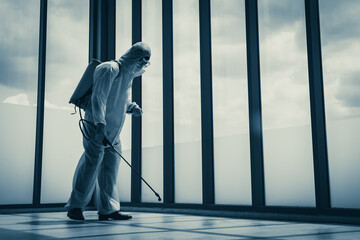 Man in virus protective suite and mask cleaning covid19 infected area, Virus disinfection concept