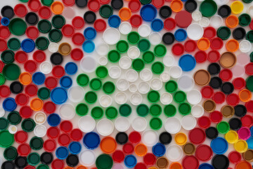 Flatlay collage with colorful plastic bottle caps and recycling sign on white background. Reuse of...