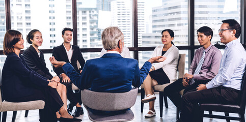 Businessman standing in front of group of people in consulting meeting conference seminar at hall...