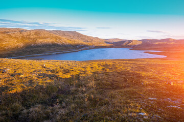 Fototapeta na wymiar Beautiful lake at sunset. Wild nature of Norway. Nordkapp, Mageroya island