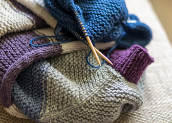 knitted sweater, knitting needles and yarn, close-up view