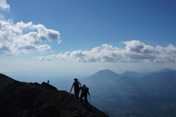 friends on top of mountain, helping each other
