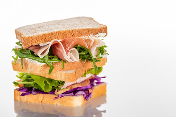 fresh sandwiches with arugula and meat on white surface