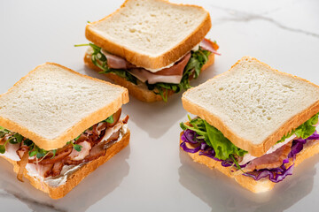 fresh green sandwiches with meat on marble white surface