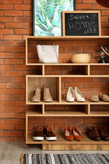 Obraz na płótnie Canvas Shelf unit with shoes and accessories in stylish modern hallway