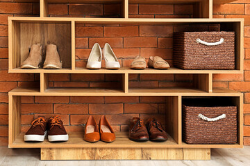 Fototapeta na wymiar Shelf unit with shoes and accessories in stylish modern hallway