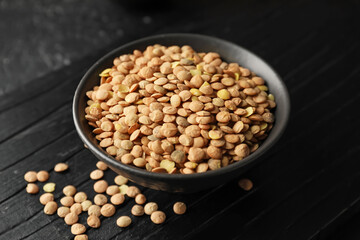 Raw lentils in bowl on table