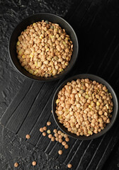 Raw lentils in bowls on table