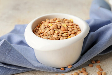 Raw lentils in bowl on table