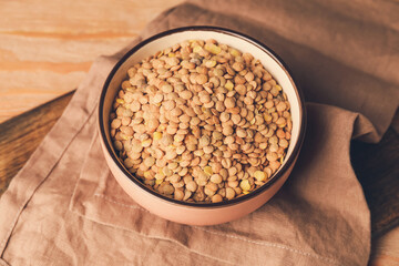 Raw lentils in bowl on table
