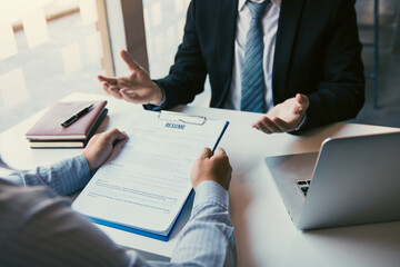 Job applicants are holding a resume document in the job interview room, job interview concept.