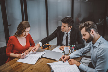 Lawyer helping a couple to fill legal papers