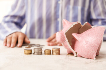 Woman counting money after breaking piggy bank