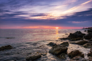 Dramatic sunset over beach with a natural pond in the foreground.