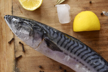 frozen mackerel on a cutting Board with seasonings