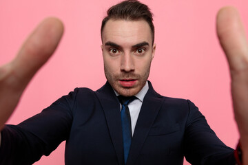 young elegant businessman in suit holding the camera