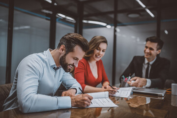 Smiling man and his wife signing a contract