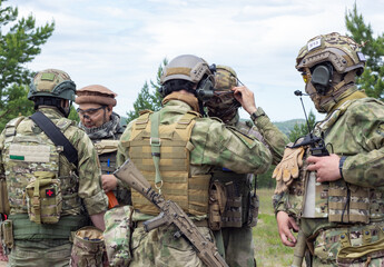 Group of fully armed american soldiers getting ready for the fight on military range, active military game airsoft.