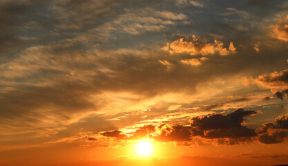 Background of the setting sun among Cumulus clouds of gray-gold color