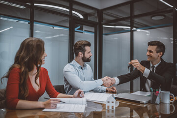 Manager giving keys from a new apartment to a couple
