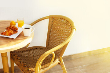 Morning breakfast on the summer terrace. Lamella chair, table, coffee and croissants. Empty Space