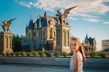 Portrait of a Little girl child lover of fairy tales on the background of a medieval castle with flowers