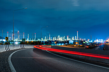 High angle with the light of the vehicle traveling at night, the background is Thai Oil Refinery Laem Chabang Industry Chonburi Province