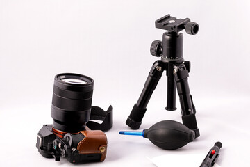 camera with lens and a pear  for optics care on a white background.
