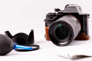 camera with lens and a pear for optics care on a white background.