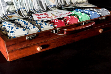 a grand casino super prize - a case full of chips, dollars and playing cards on a black background.