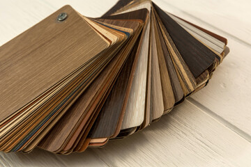 Samples of laminate  planks on white wooden desk for new construction or renovation building