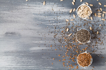 sunflower seeds, flax seeds and chia on blue wooden background