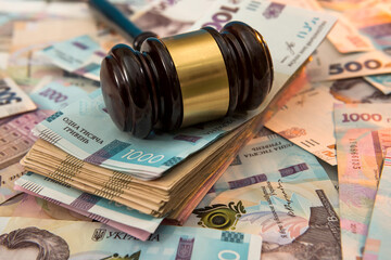 wooden hammer on ukraine money as background. 500 and 1000 new uah grivna